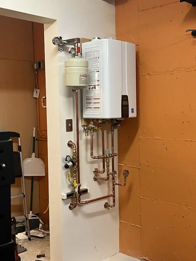 Plumbing technician inspecting water heater connections in Elma